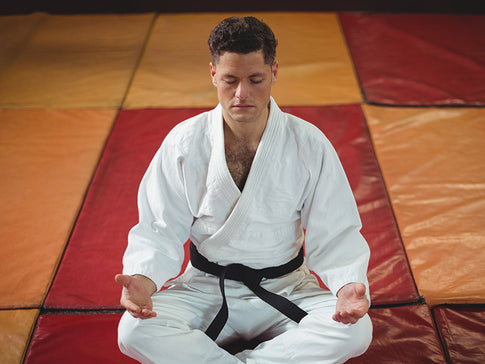 karateka haciendo yoga sobre el tatami