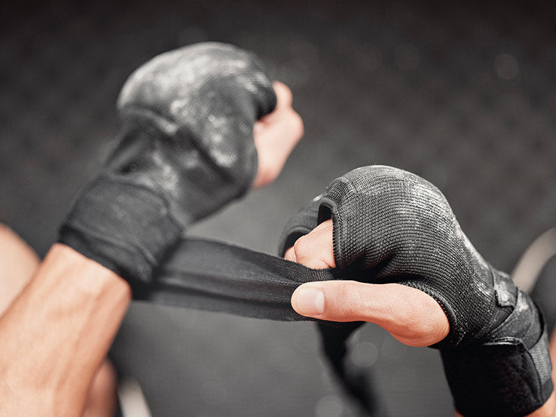 luchador se pone las vendas y guantillas para practicar artes marciales mixtas (MMA)