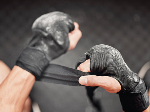 luchador se pone las vendas y guantillas para practicar artes marciales mixtas (MMA)