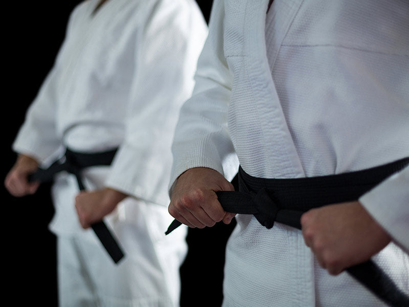 karateka se ajusta el cinturon para defenderse de un ataque